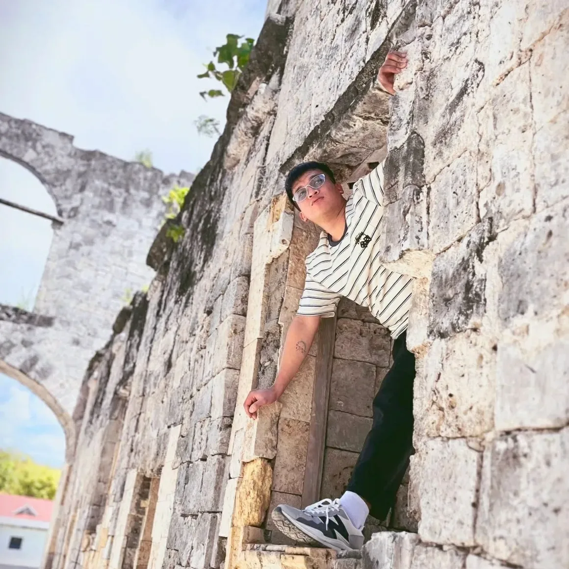 A guest posing in a window of the Cuartel ruins in Oslob