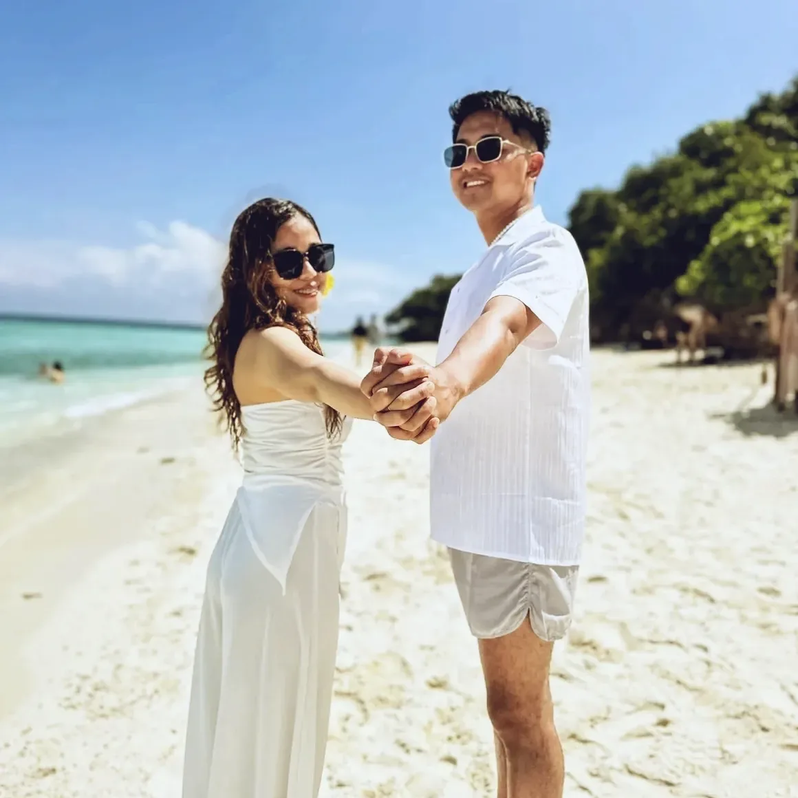 A couple holding hands on the beach at Sumilon Island