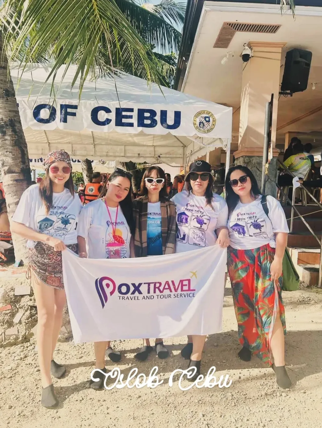 Five guests in Pox Travel shirts holding a Pox Travel towel in Oslob