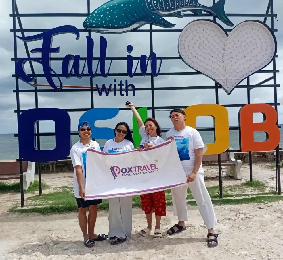 Guests with a Pox Travel towel at the Fall in Love with Oslob sign